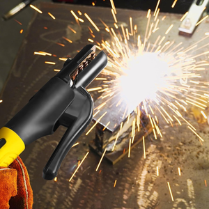 Gloved hand arc welding a steel plate with a 600A electrode holder, sparks flying over the workbench